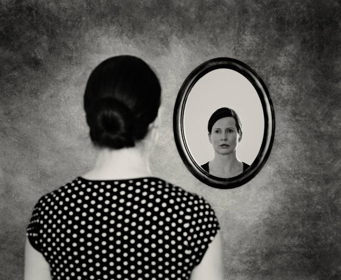 Manuela Deigert Bildsprache Identität, schwarzweißes Selbstportrait mit Spiegelbild in einem Wandspiegel