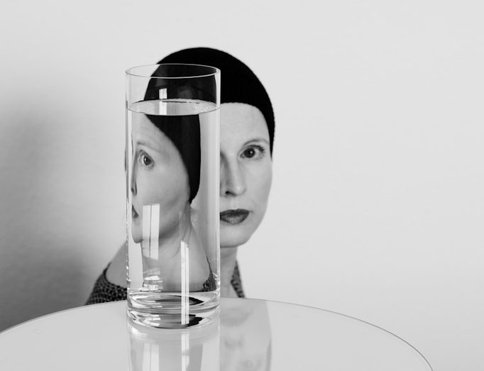 Manuela Deigert Bildsprache schwarzweißes Selbstportrait mit Reflektion meiner selbst in einer mit Wasser gefüllten Glasvase