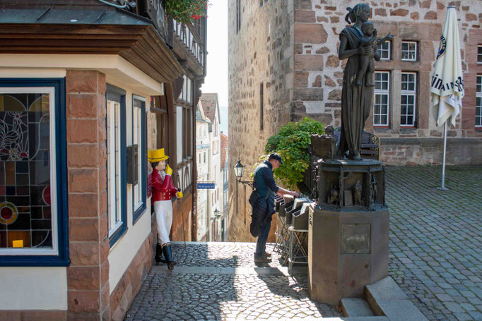 In der Marburger Altstadt blättert ein Passant in einer Kiste mit gebrauchten Vinyl-Schallplatten. Eine Werbefigur scheint ihm dabei zuzuschauen. Foto: Kai-Uwe Ruf
