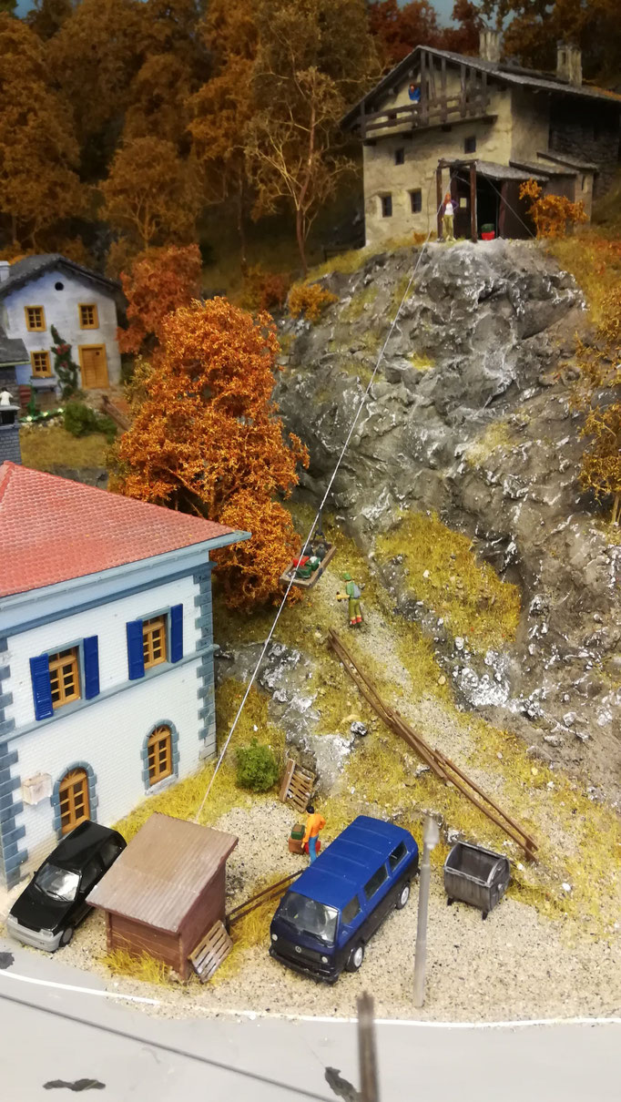 Zwischen den Häusern führt auch ein beliebter Wanderweg in die Berge. Hier ist auch die Materialseilbahn zu sehen, die das oberste Gebäude versorgt. 