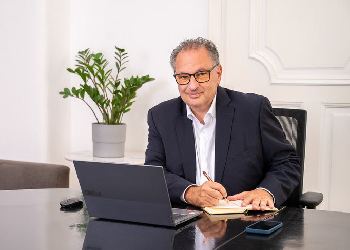 Businessportrait eines Managers am Schreibtisch in einem Büro.