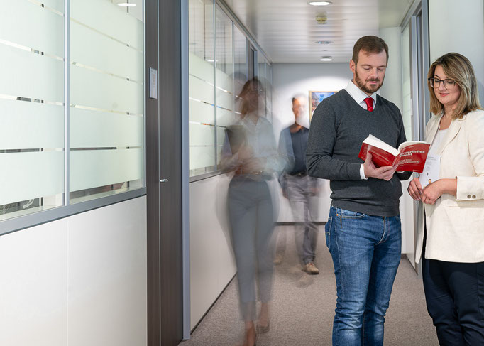 Gruppe von Mitarbeitenden im Gespräch im Büro, Branche Versicherung.