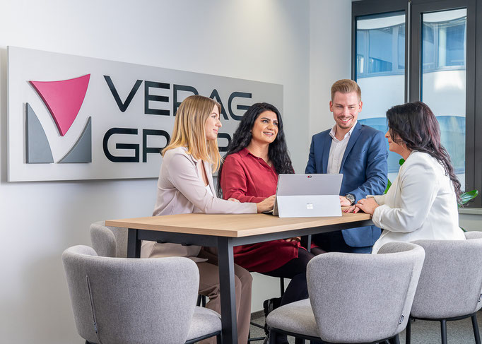 Gruppe von Mitarbeitenden im Gespräch im Büro, Branche Versicherung.