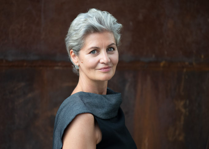 Portrait einer Dame vor rostigem Hintergrund.