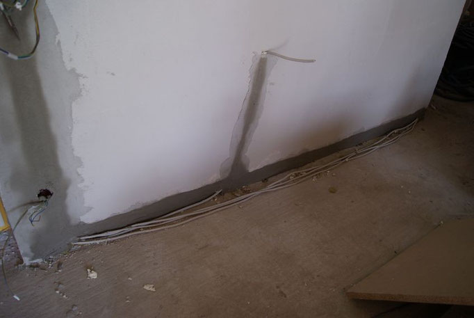 Pfusch am Bau - der Elektiker macht für die Kabel einen Schlitz in die Wand und der Putzer spachtelt diesen wieder zu ohne die Kabel mit zu verputzen.