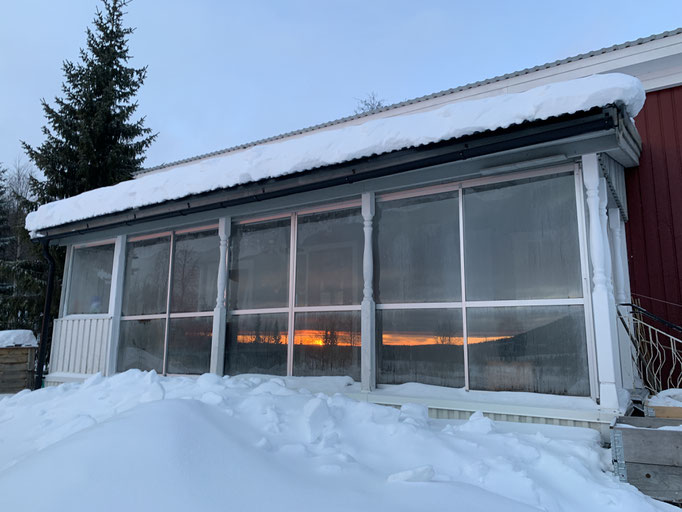 Spiegelung der Abendstimmung im Wintergarten der Hütte Björk