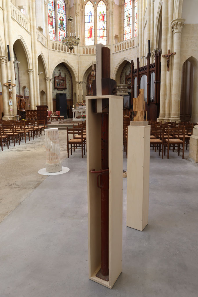 Au travers, bois de chêne, pierre de Bourgogne, étai et contreplaqué, 170x25x25 cm, 2022. Photo : Gabriel Vieille.  Vue de l'exposition À la vitesse de la poussière, Art en Chapelles, Doubs. Soutenue par la DRAC BFC.