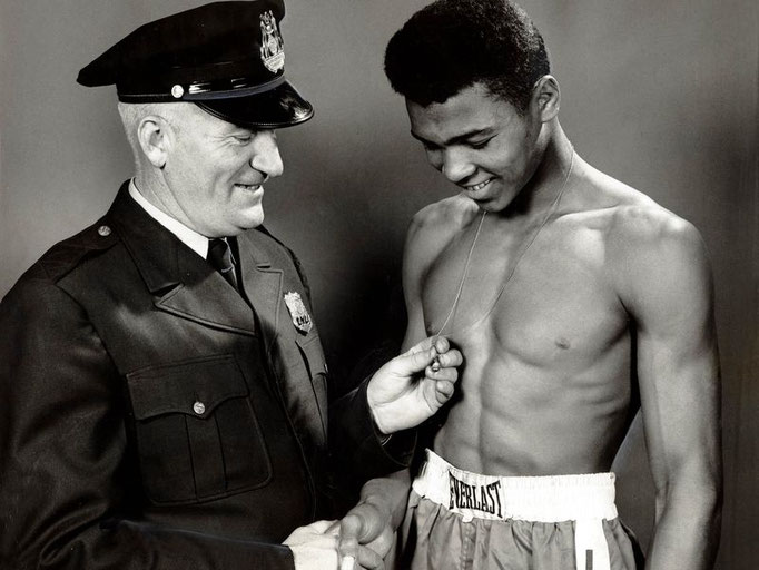 Policeman and mentor Joe Martin congratulates Cassius Clay as he admires his golden gloves ring, Mar 29, 1959; Louisville, KY, USA (Chas Kays/The Courier-Journal-USA TODAY Sports)