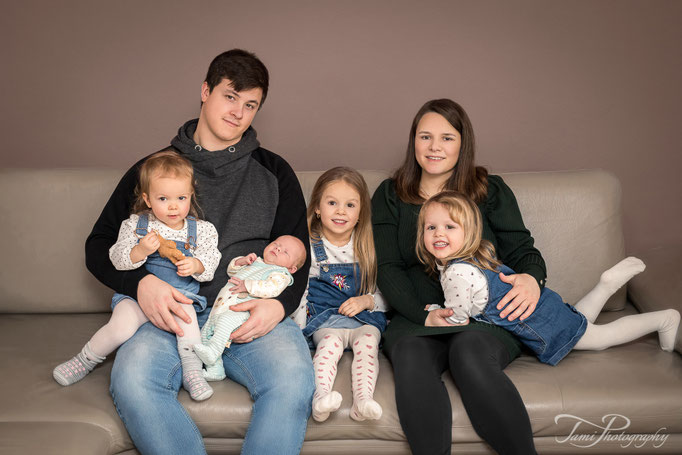 Natürliche Familienfotografie Ulm – Eltern mit vier Kindern, inklusive Baby, zuhause im gemütlichen Wohnzimmer