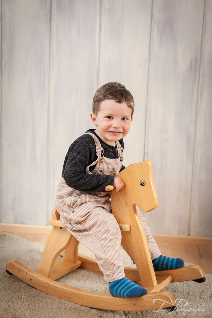 Kinderfotografie Ulm – kleiner Junge auf einem Schaukelpferd zuhause