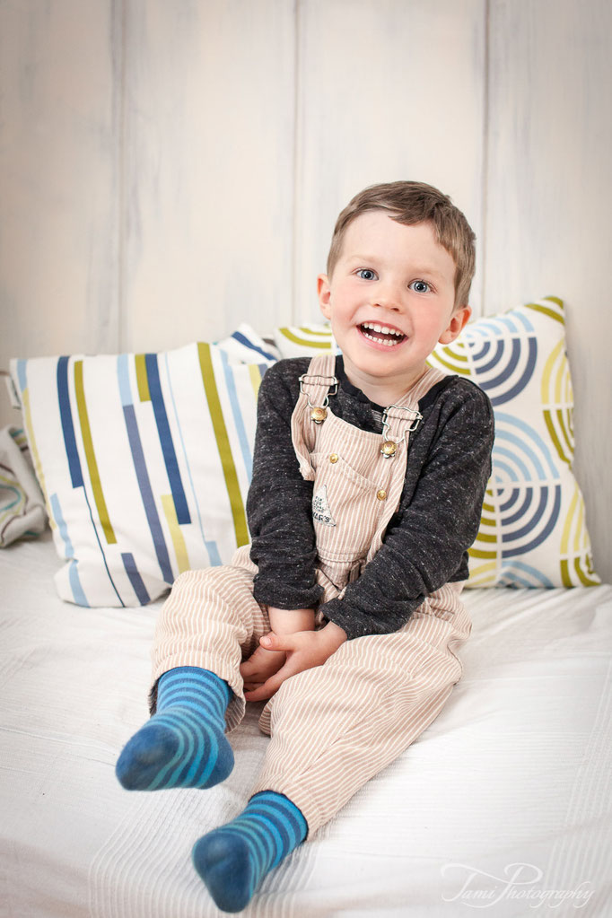 Kinderfotograf Ulm – lachender kleiner Junge zuhause beim Familienshooting im Wohnzimmer