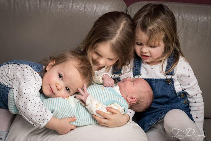 Familienfotografie Ulm vom Kinderfotograf Ulm – drei Mädchen begrüßen ihren kleinen Baby Bruder zuhause
