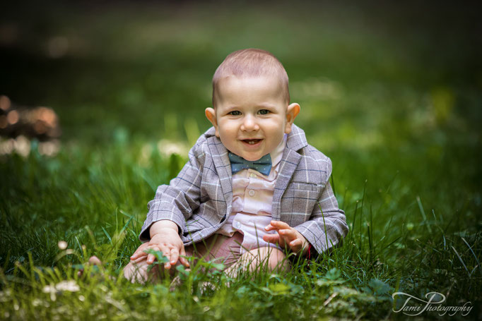 Kinderfotografie in Ulm – kleiner Junge sitzt im Gras bei einem natürlichen Fotoshooting im Alten Friedhof Ulm