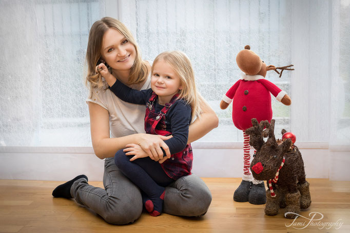 Familienfotografie Ulm – Mädchen spielt mit Mama bei weihnachtlicher Dekoration zuhause