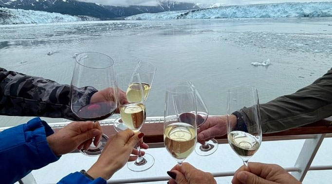 Hände halten Champagnergläser auf der HANSEATIC inspiration in der Icy Bay in Alaska