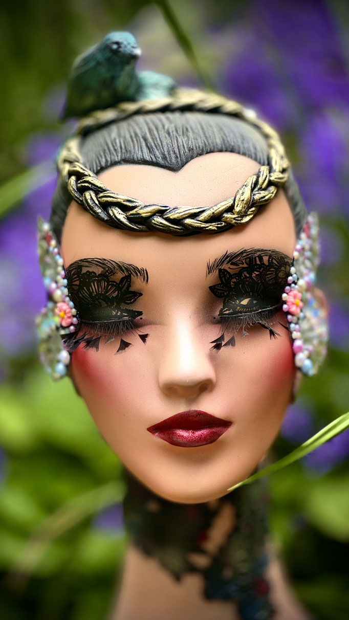 sur tête base blanche, Aérographe, pâte a modeler, marqueurs, strass, ailles de papillon pour regard,  vernis mat