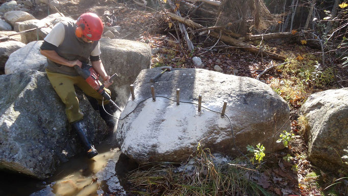 Jed drills to split a large boulder to make a better stepping surface