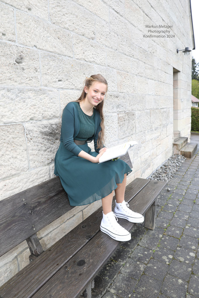 coole Konfi-Fotos, Konfirmation in Alfdorf-Hellershof, Kaisersbach, Welzheim, Kirchenbild, Konfirmandin vor Kirche auf einer Bank sitzend, Markus Metzger Photography, https://www.markus1.de