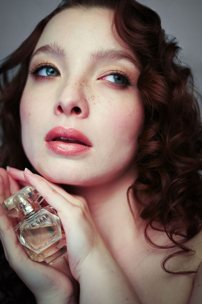 dezentes glowy makeup model mit parfumflsche in hand