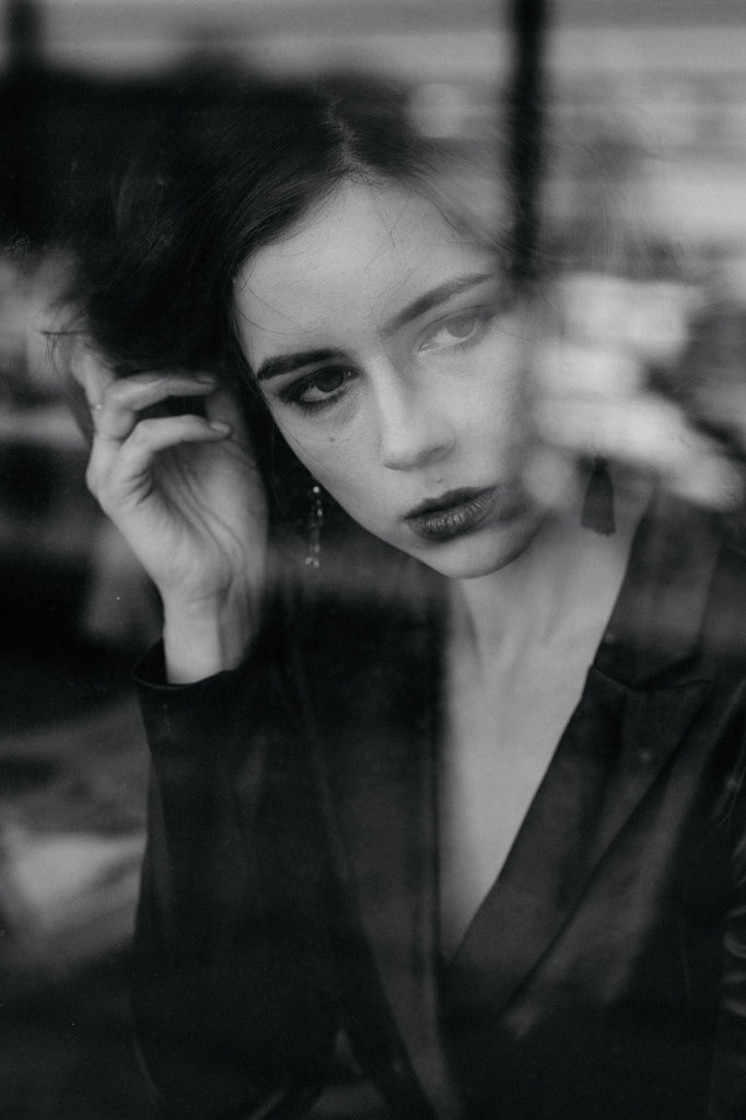 elegantes Model in schwarz/weiß hinter scheibe