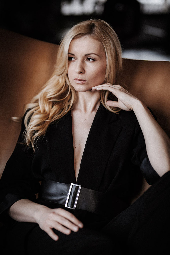 Frau im Sessel schwarzes Kleid