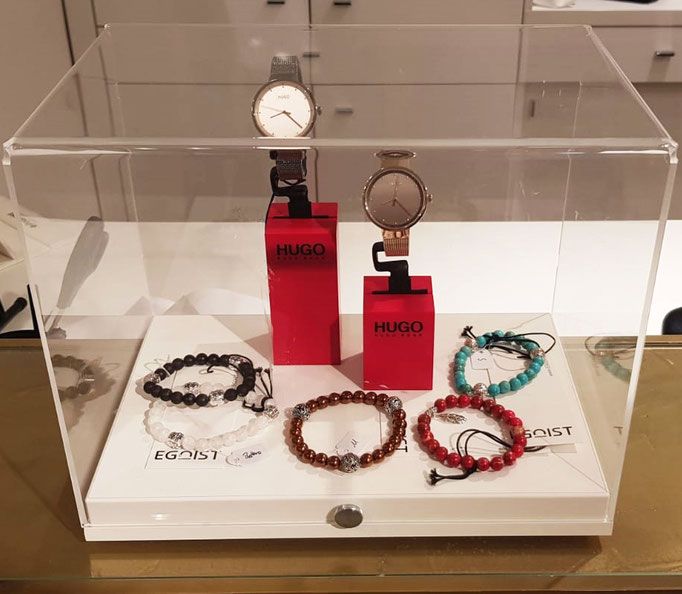  BEHERO Armbänder liegen neben zwei HUGO BOSS Uhren in einer Vitrine im EGOIST