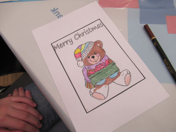 Einen Weihnachtskarte mit einem Teddy und dem Schriftzug Merry Christmas wurde bunt ausgemalt.