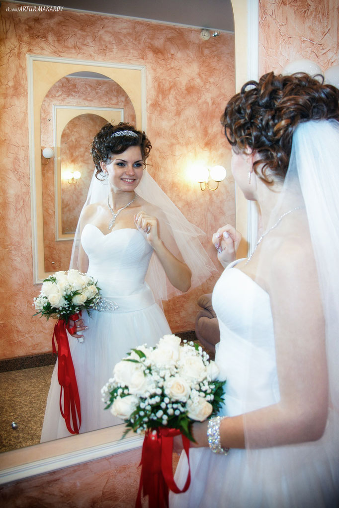Невеста прихорашивается перед зеркалом