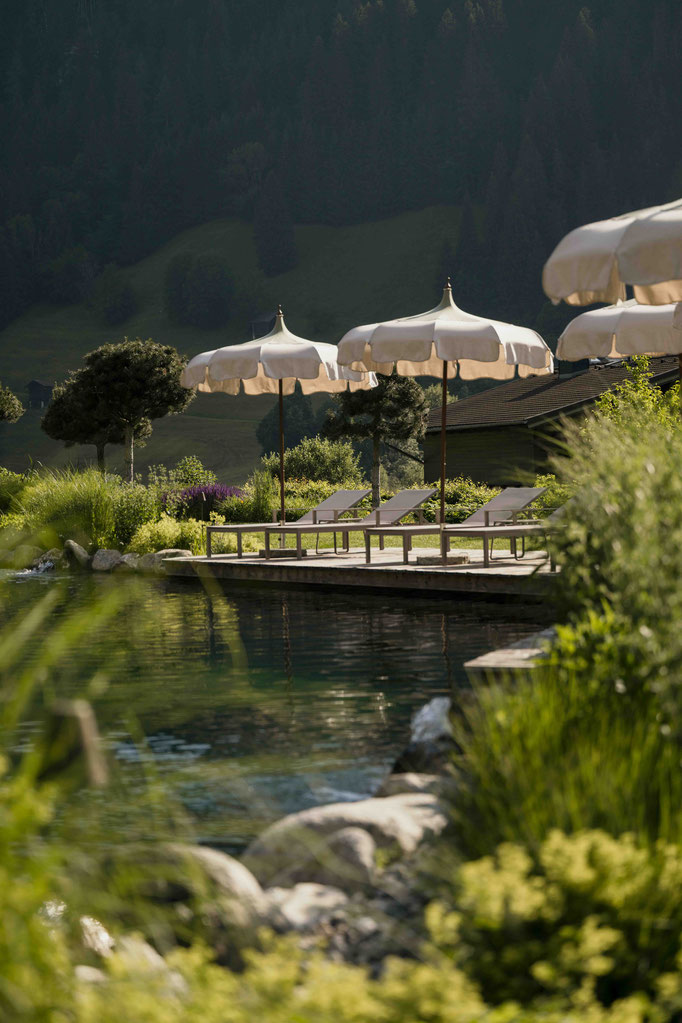 Badeteich mit Liegestühlen und Badesteg im 5 Sterne Wellnesshotel Nesslerhof in Großarl