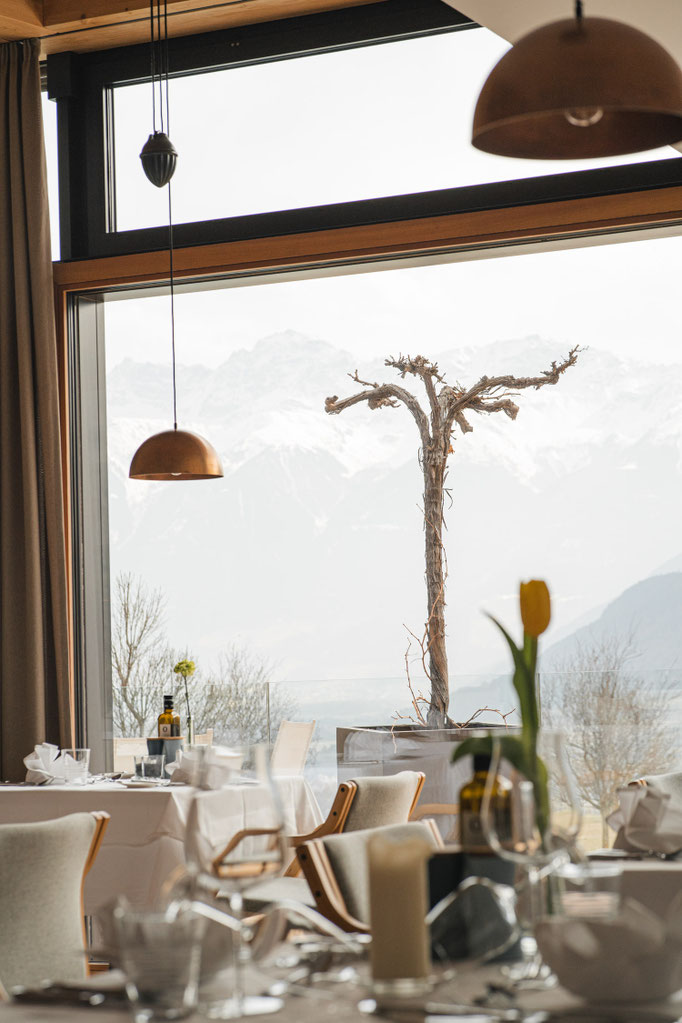 Elegantes Restaurant mit Bergblick durch große Panoramafenster.