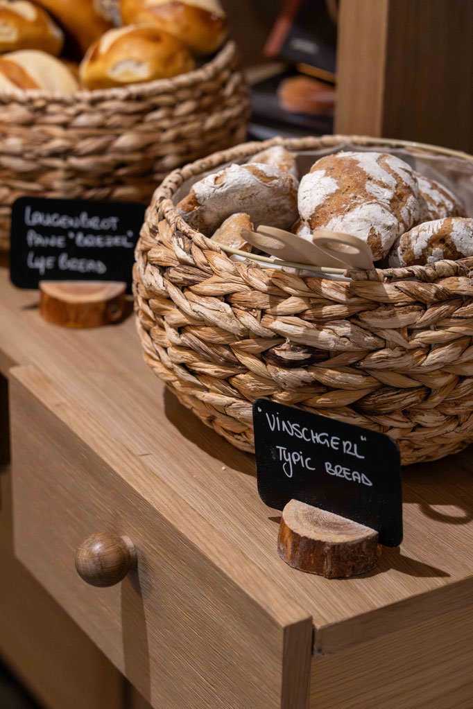Baskets of freshly baked bread and regional specialities at the breakfast buffet at the Boutique Hotel PETRUS in Reischach-Bruneck • South Tyrol, for a delightful start to the day.