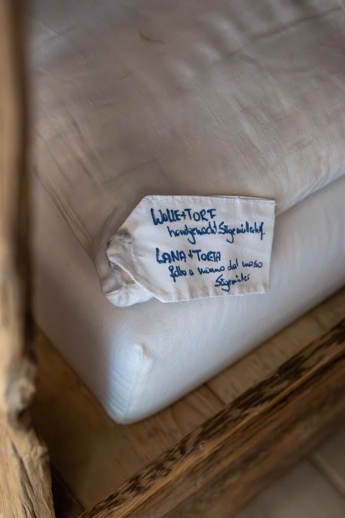 A close-up of a handmade woollen cushion made from regional natural materials in the wellness area of the PETRUS boutique hotel in Reischach-Bruneck • South Tyrol, which emphasises the sustainable and natural interior design style.