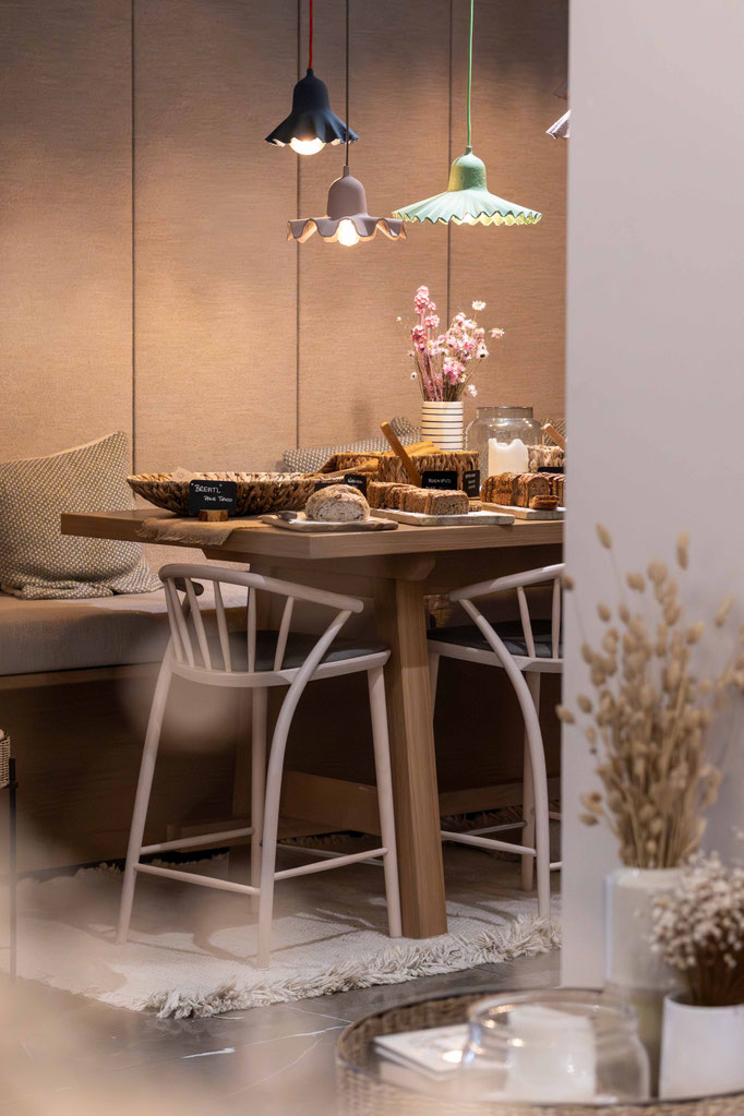 Gemütlicher Frühstücksbereich mit gedecktem Tisch, regionalen Backwaren und dekorativen Pendelleuchten im Boutiquehotel PETRUS in Reischach-Bruneck • Südtirol, der zum genussvollen Start in den Tag einlädt.