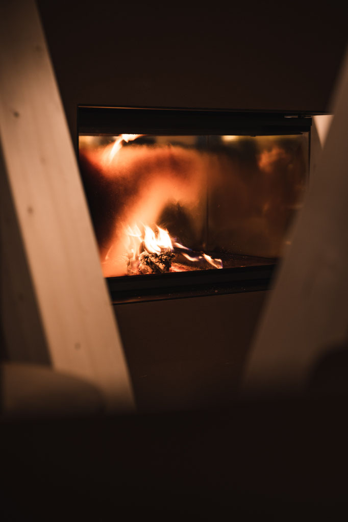 Gemütlicher Kamin im Garberhof mit warmem Feuerlicht und ruhiger Atmosphäre.