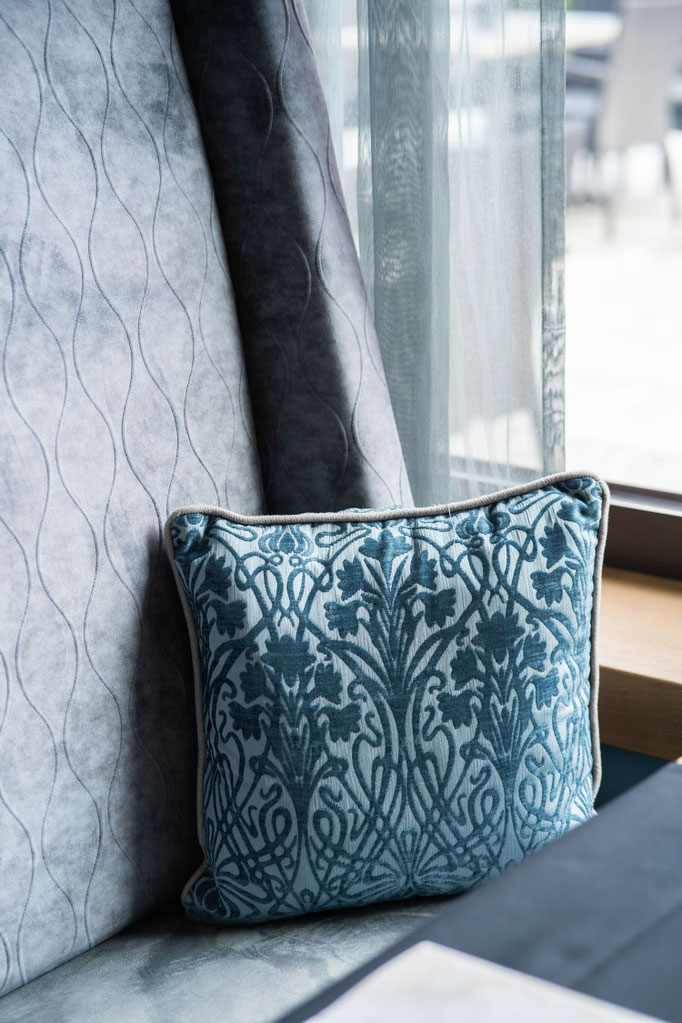 Close-up of a decorative bench with a patterned cushion at the Hochkönigin Wellness Hotel in Maria Alm, Salzburg