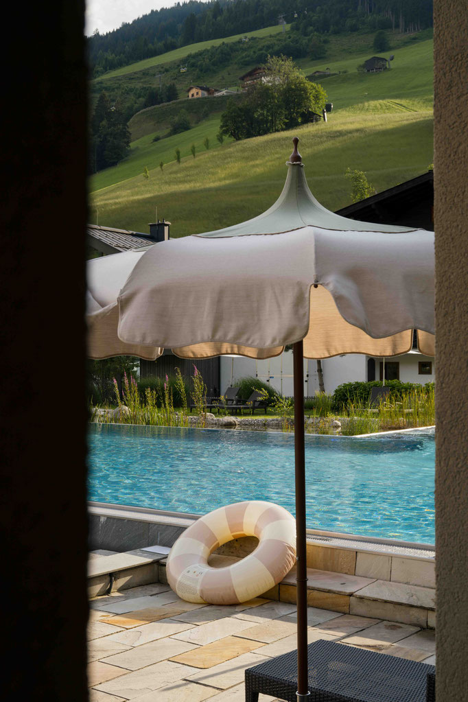 Sonnenschirm und Schwimmreifen beim Outdoorpool - NESSLERHOF in Großarl • 5-Sterne-Wellnesshotel im Salzburger Land