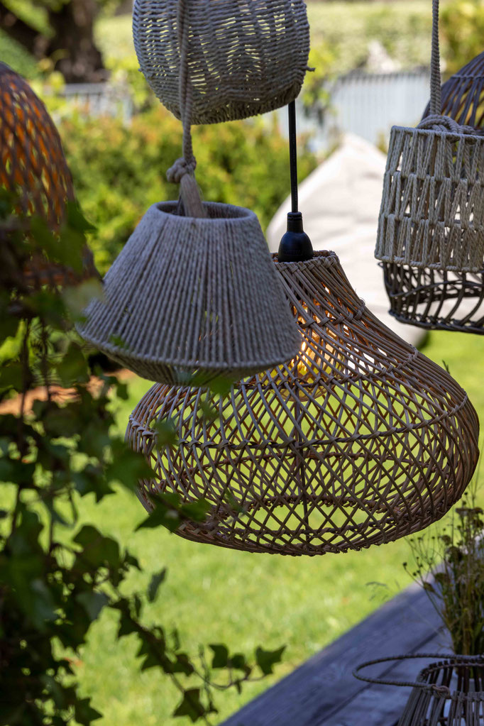 Woven pendant lights as stylish garden décor in the outdoor area of the PETRUS boutique hotel in Reischach-Bruneck • South Tyrol, surrounded by lush greenery and a natural setting.