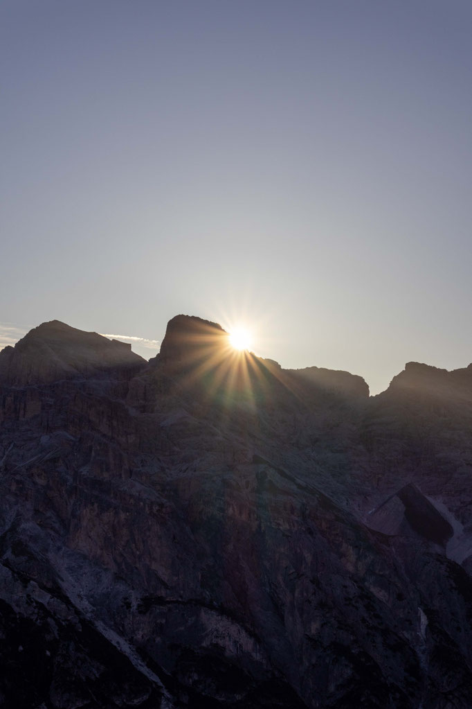 Sunrise over the Dolomites, with rays of sunlight streaming from behind the mountain peaks – a breathtaking natural spectacle in the surroundings of the Boutique Hotel PETRUS in Reischach-Bruneck, South Tyrol.