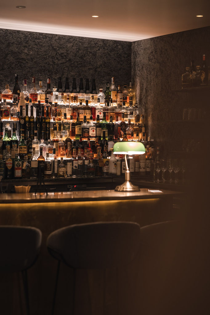 Atmosphärische Hotelbar im Garberhof mit beleuchteten Spirituosen und stilvoller Abendstimmung.