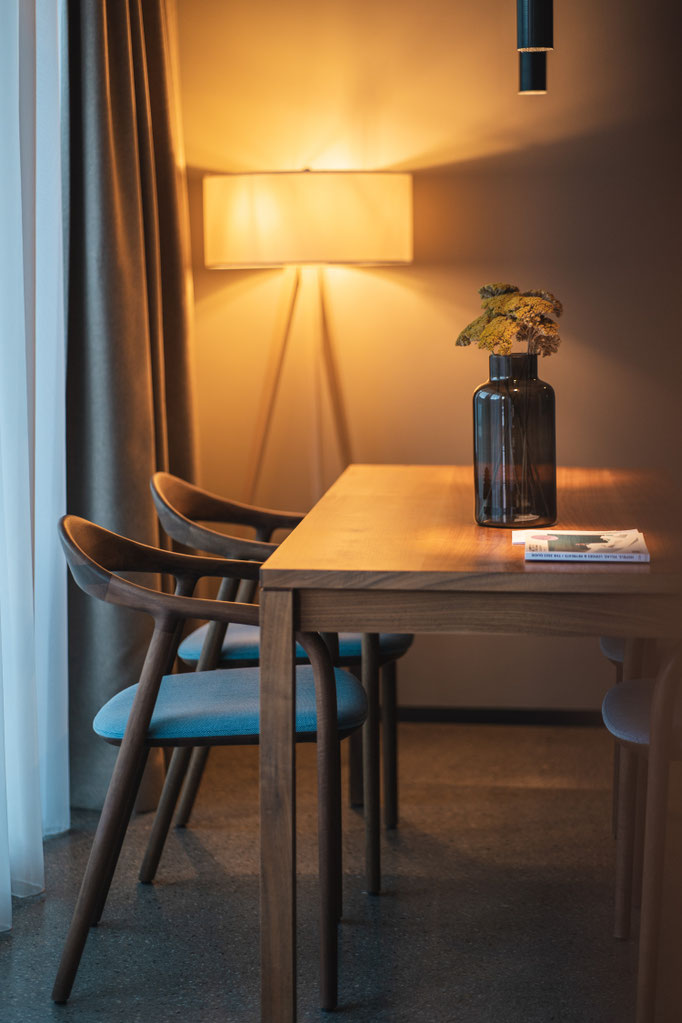 A stylish dining area at the Garberhof, featuring warm lighting, a wooden table and modern décor.
