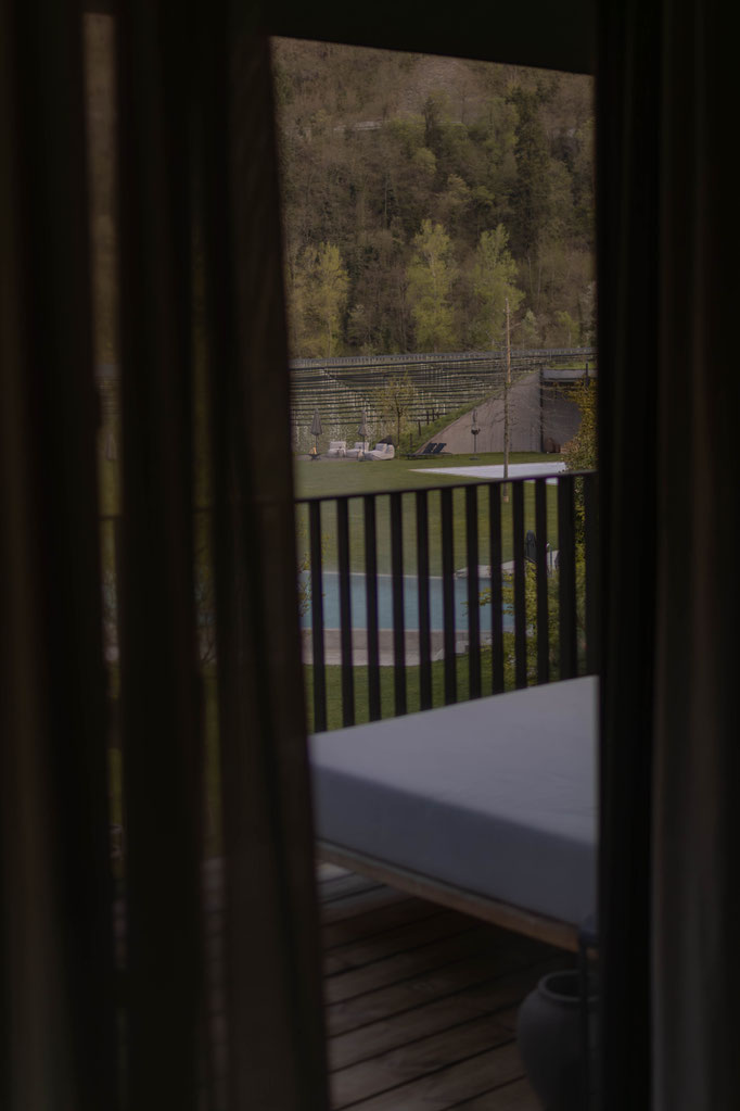 View from the balcony of a room at the Apfelhotel, looking out over the pool, gardens and the surrounding natural landscape.