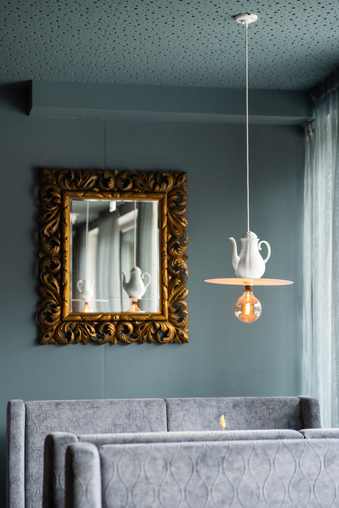 A stylish seating area with a designer lamp and mirror in the restaurant of the Hochkönigin Wellness Hotel in Maria Alm, Salzburg