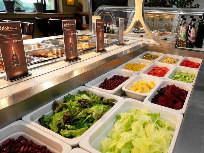 Salatbuffet mit Blattsalat, Gemüse, Mais, Bohnen und Zitronen