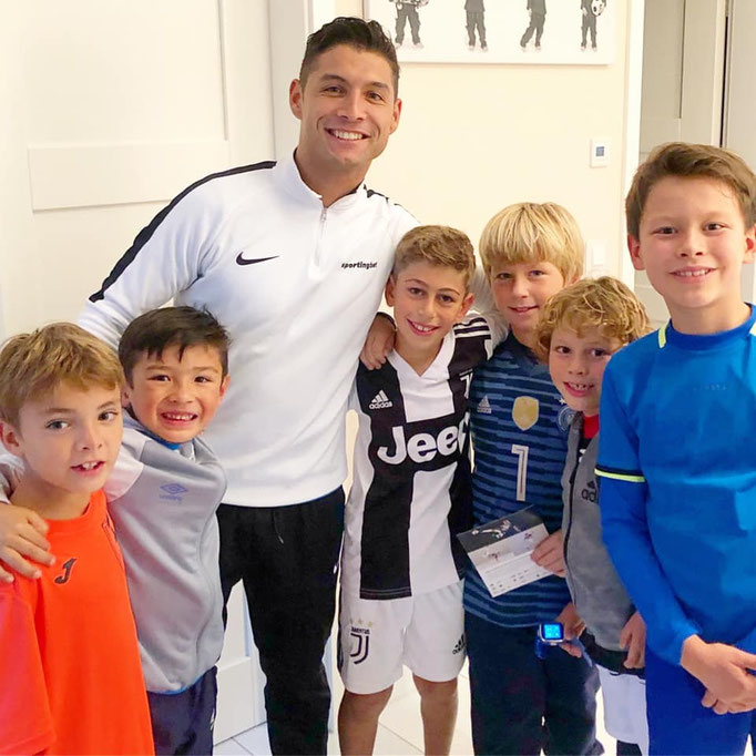 Gruppenfoto Fußball-Geburtstag: Kinder im Trikot-Look mit Pokal und Medaillen.