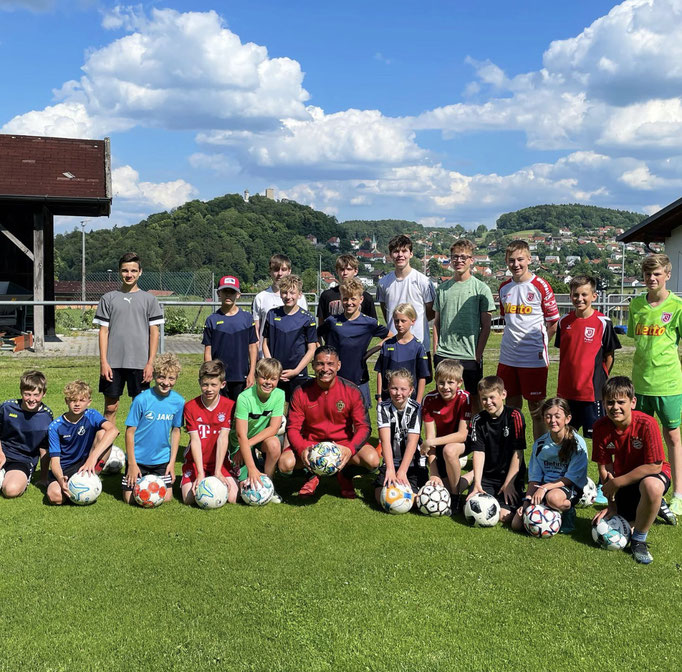Mannschaftsfoto zum Fußball-Kindergeburtstag: Glückliche Kinder posieren mit Trainer Saki.