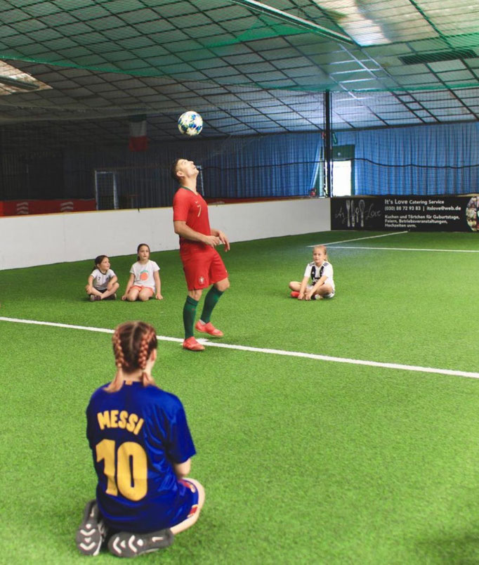 Fußballshow beim Kindergeburtstag in Berlin: Kinder schauen den Freestyle-Tricks gespannt zu.