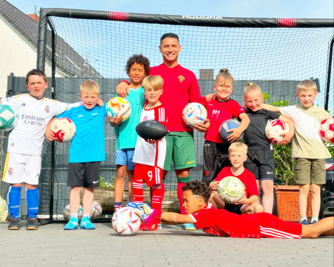 Gruppenfoto zum Fußball-Kindergeburtstag: Glückliche Kinder feiern mit dem Ballkünstler.