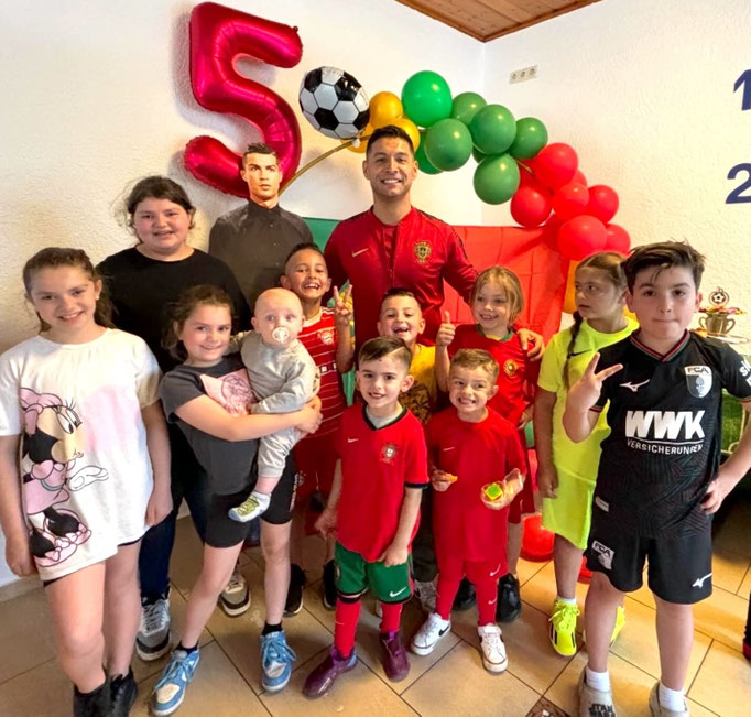 Gruppen-Action beim Fußball-Kindergeburtstag: Alle Kinder jubeln gemeinsam mit Trainer Saki.