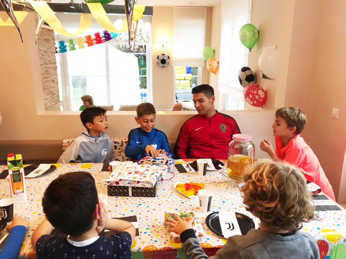 Geschenke auspacken bei der Fußballparty zu Hause mit passender Mottoparty-Deko.