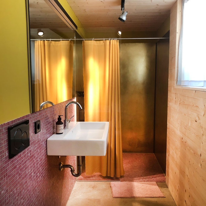 Badezimmer, Blick auf die golden strahlende Dusche.